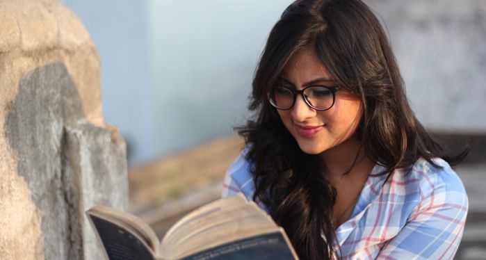 young indian woman or teen reading a book