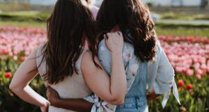 young women or teen girls holding onto each other