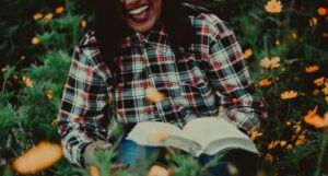 a woman laughing with a book in her lap