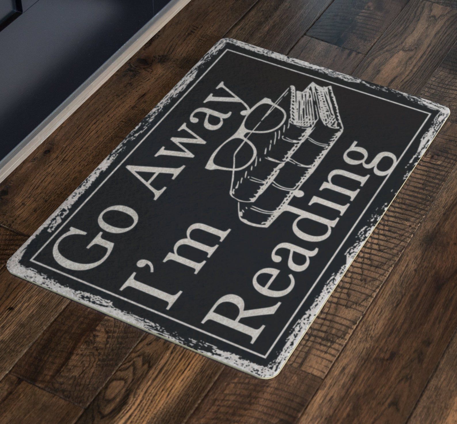 Image of black and white doormat that reads "Go Away. I'm Reading."