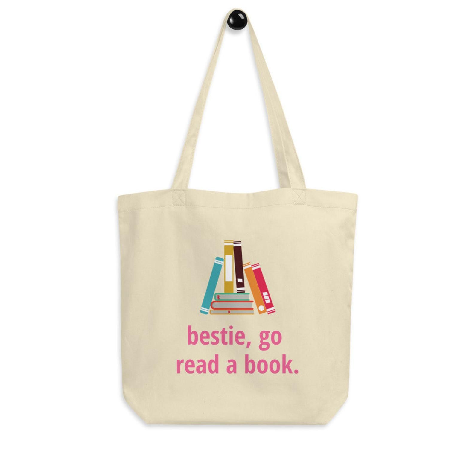 a beige tote bag with a book graphic and text that reads: bestie, go read a book