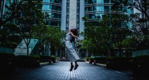 a woman who appears to be levitating off the ground in front of a glass skyscraper https://unsplash.com/photos/rFrkhK7wuHs