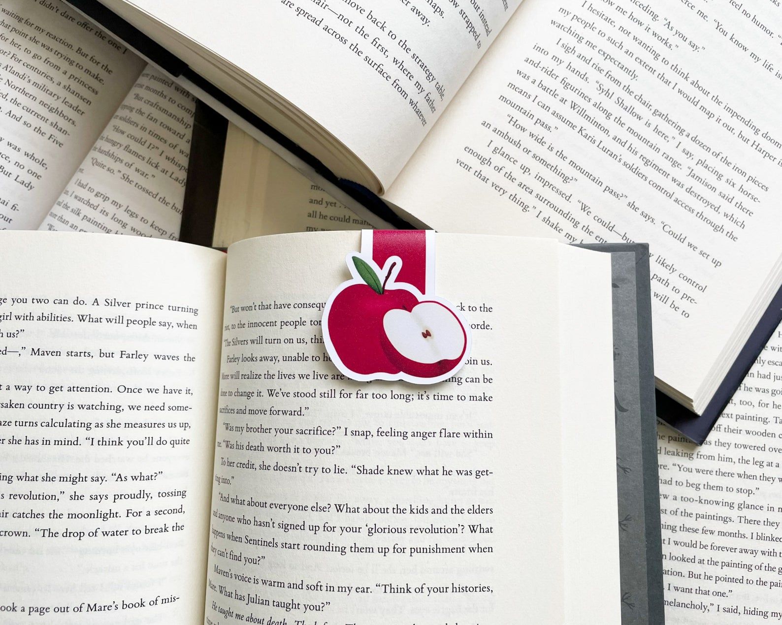 Image of a magnetic bookmark in the shape and color of a red apple. 
