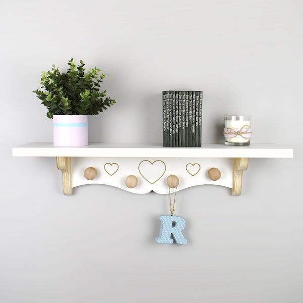 image of white nursery wall bookshelf with hanging pegs