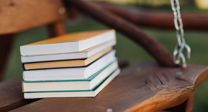 stack of books on bench https://www.pexels.com/photo/stack-of-books-placed-on-seat-of-wooden-swing-4218588/