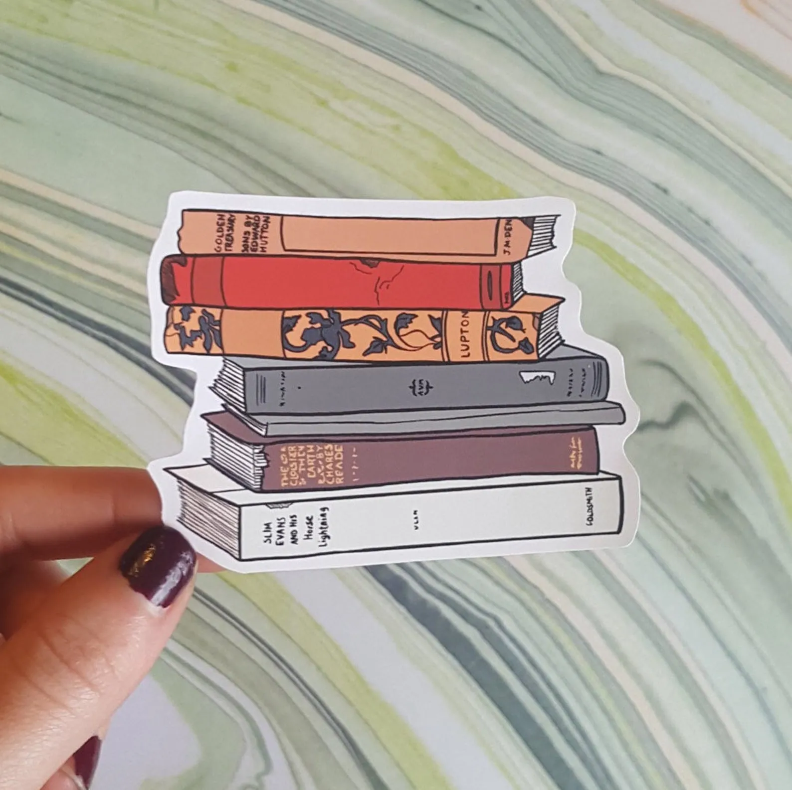 Image of a sticker with fall-colored book spines. 