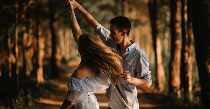 teen couple dancing with each other outside