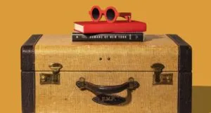a brown and mustard suitcase with a stack of books and bright red plastic sunglasses on top