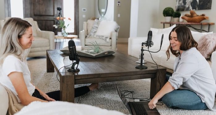 person in white shirt using black laptop computer on brown wooden table