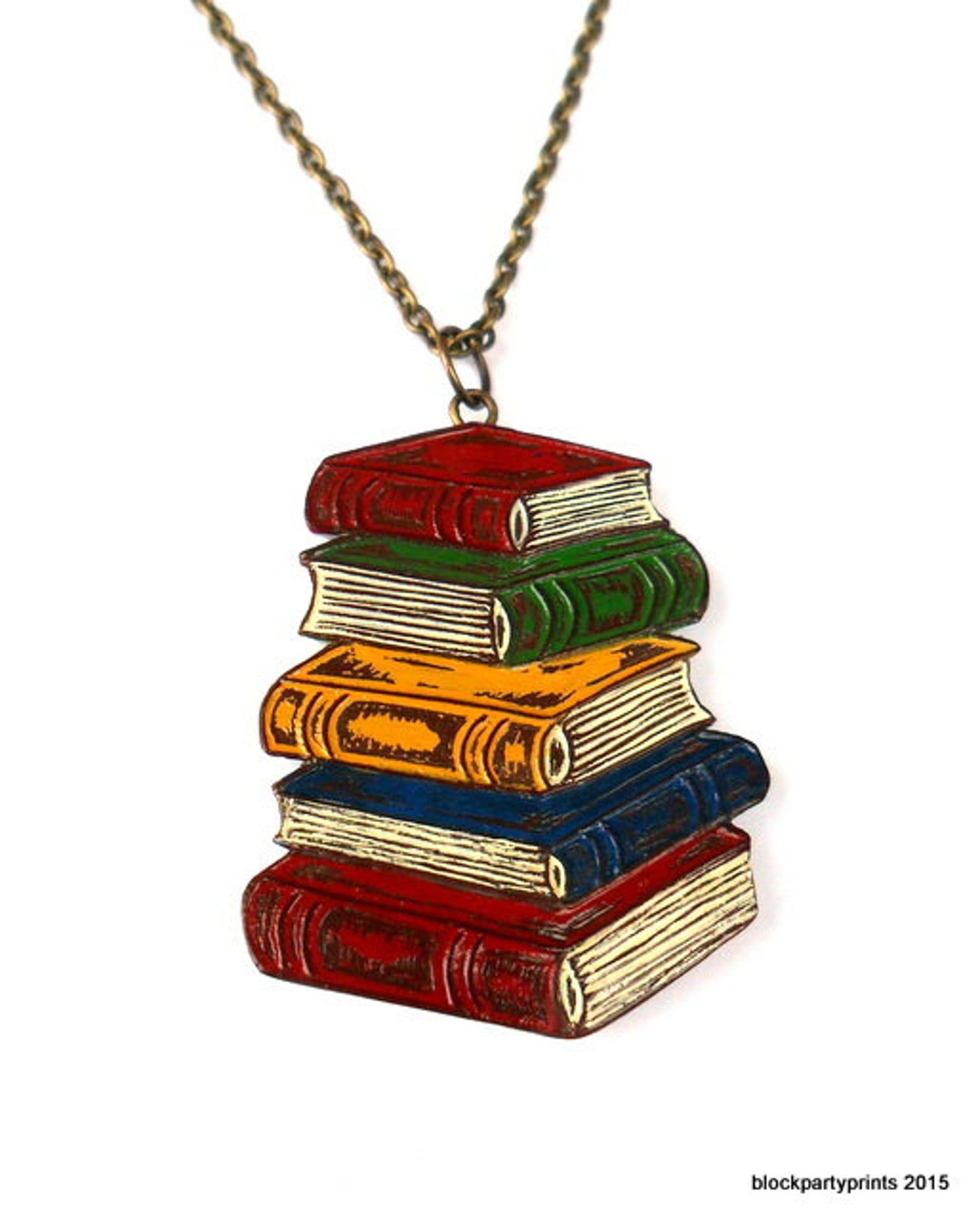 A pendant of red, green, blue, and yellow antique looking books on a bronze chain.