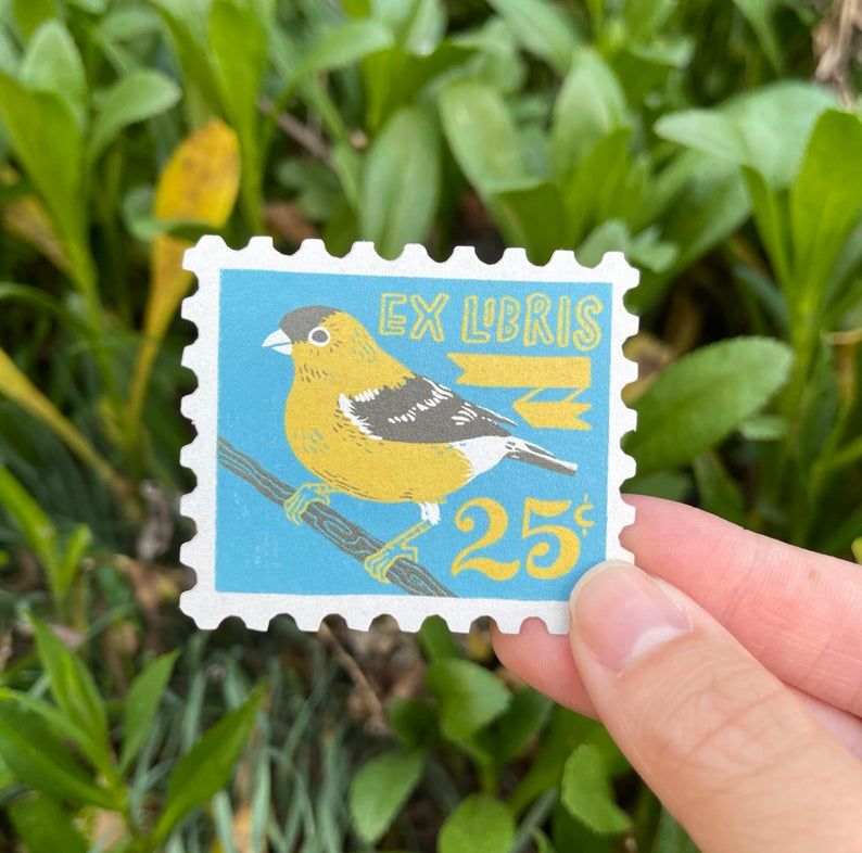 A sticker styled to look like a blue stamp with an illustrated goldfinch that reads "ex Libris"