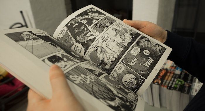 Image of an open manga between hands