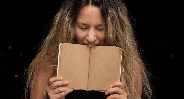 Image of a person biting a book