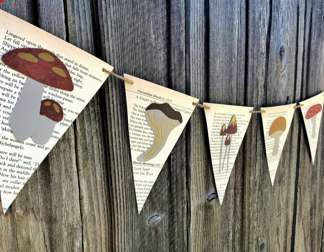 Image of a banner made of recycled book pages, and each page has a mushroom on it. 