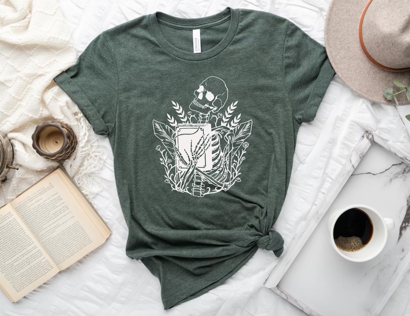 Heather gray t-shirt with a white skull hugging a book. 