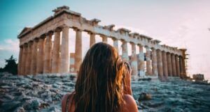 image of woman looking at ancient greek ruins