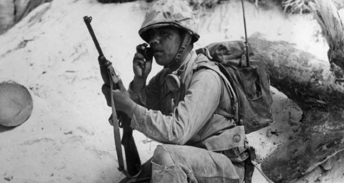 a Navajo Code Talker relaying a message on a field radio during World War Two