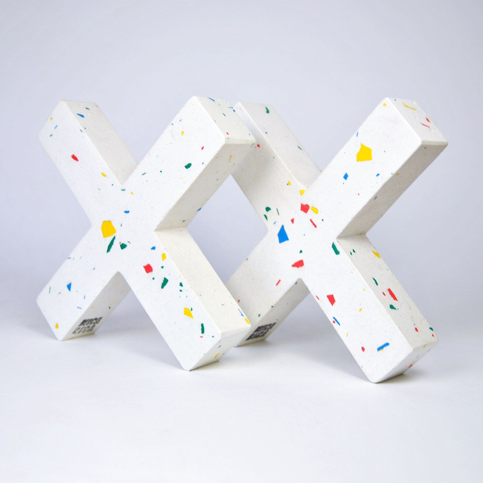 2 white bookends flecked with color in the shape of "X"