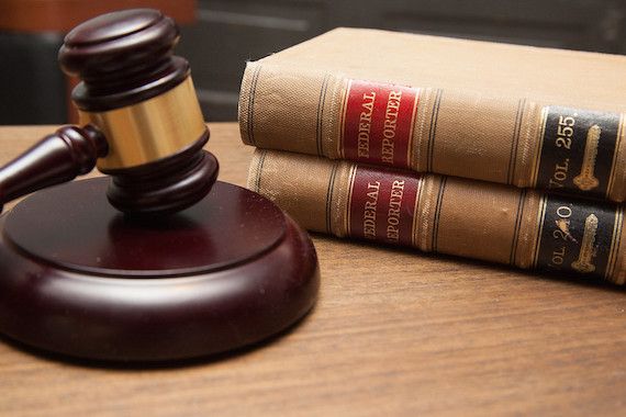 A photo of a gavel and Federal law books