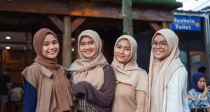 image of four teen girls wearing hijabs smiling at the camera