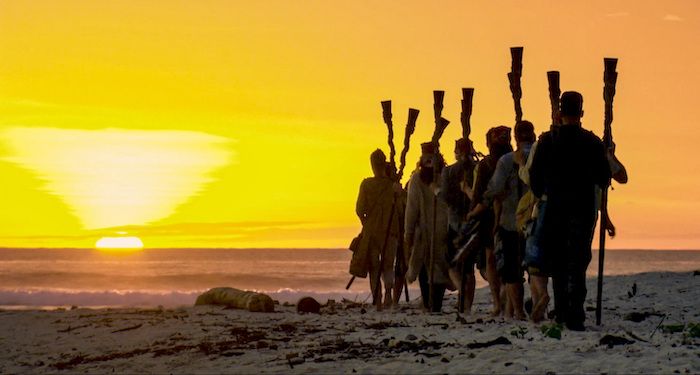 still from Survivor with cast members looks out at sunset