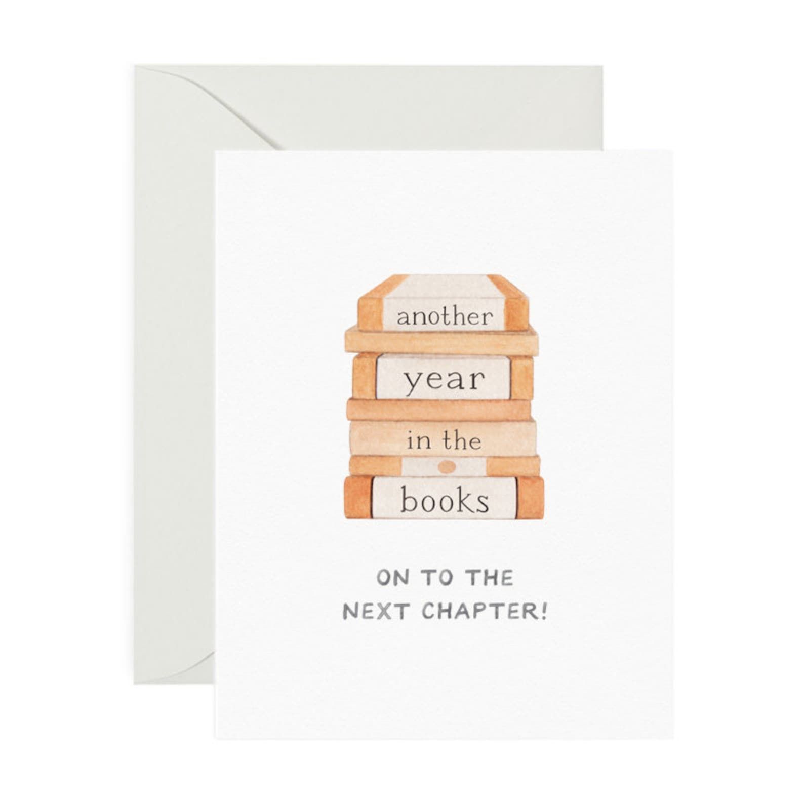 A stack of books on a white card that reads "Another Year in the Books - On to the next chapter!"