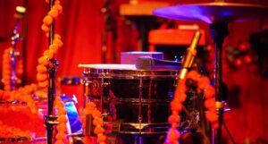 a snare drum, microphone, and high hat drum lit by red light