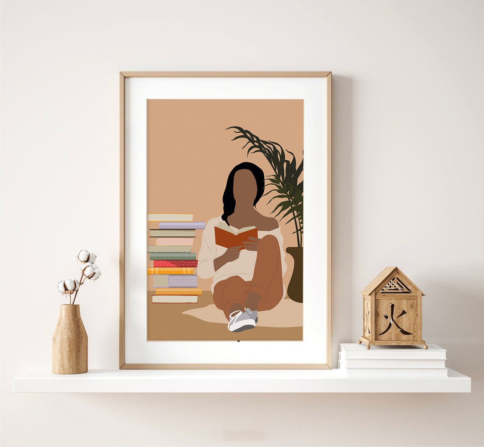 Image of a print featuring a Black woman wearing tennis shoes, a white sweatshirt, reading a book. She is sitting beside a pile of books. 
