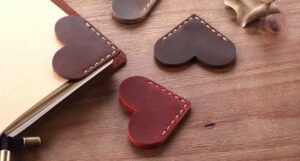 A collection of leather hearts stitched together at the point and used as corner bookmarks.