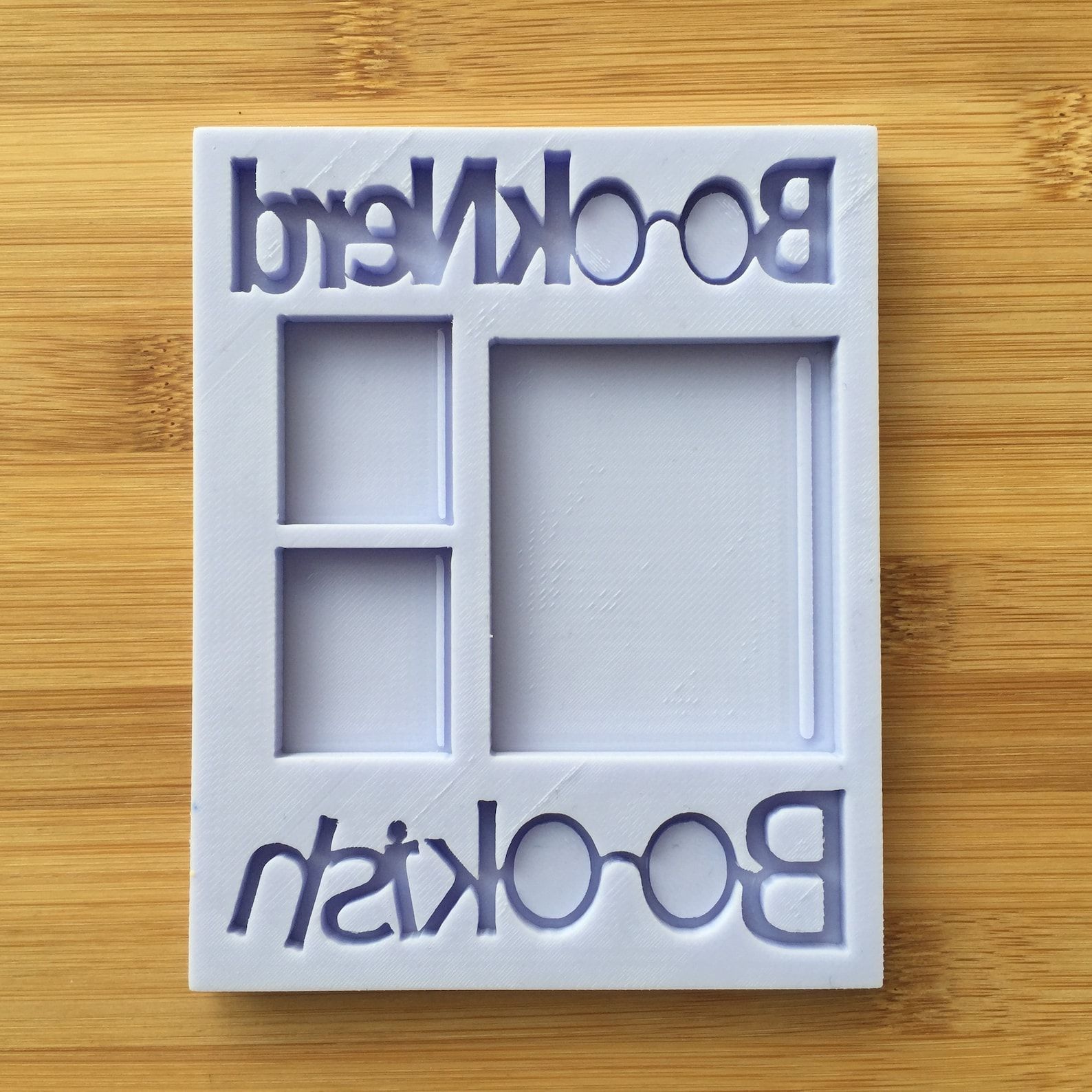 A gray silicone tray with various book shapes and "Book Nerd" and "Bookish" lettering.