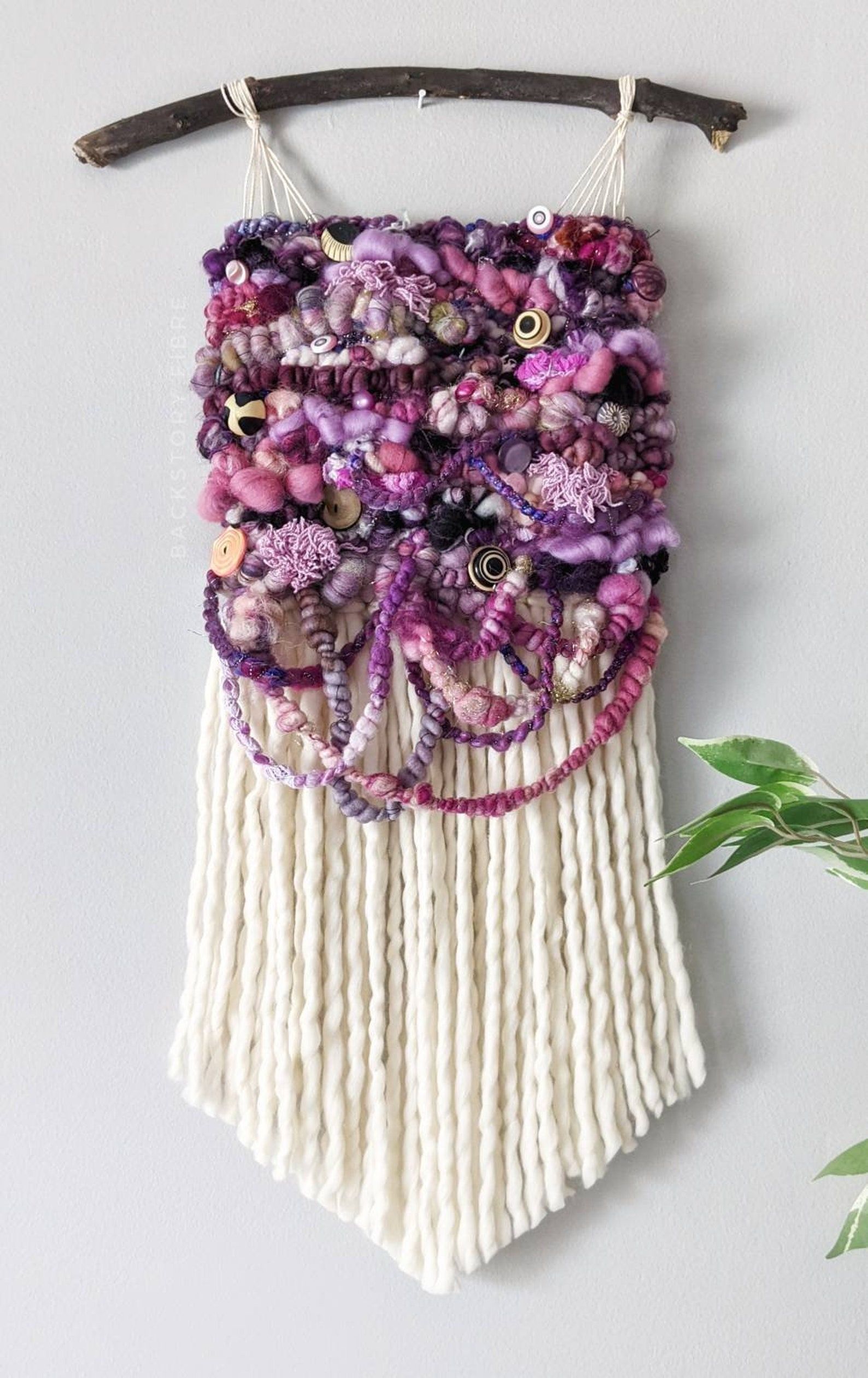 Multiple purple designs on macrame. 