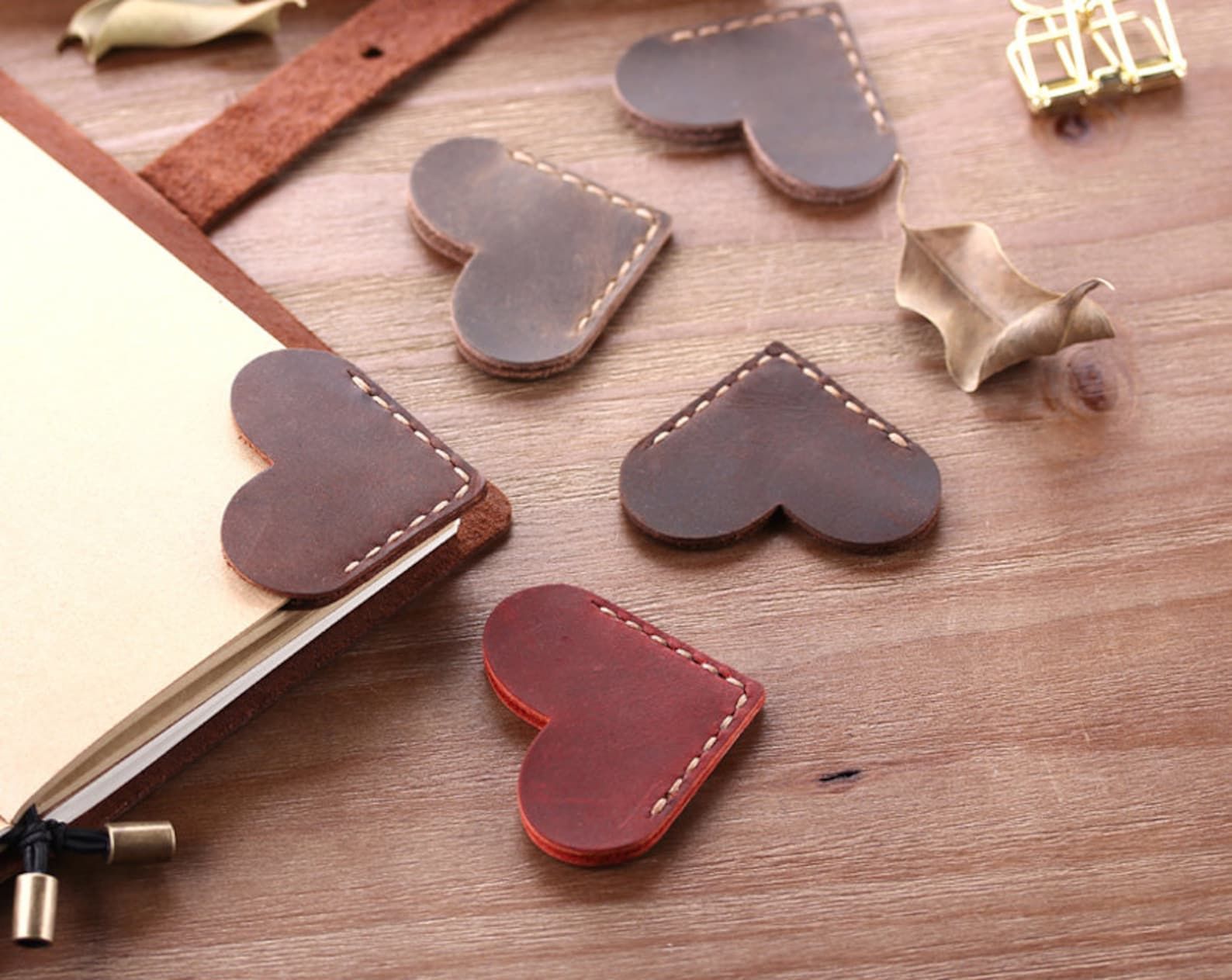 A collection of leather hearts stitched together at the point and used as corner bookmarks.