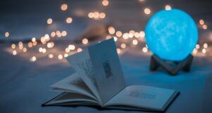 Image of an open book with twinkle lights behind it