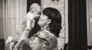 greyscale image of a woman holding a baby