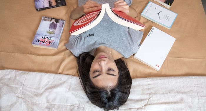 Image of a person with olive skin and dark hair reading a book