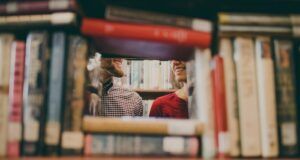 Image of a couple smiling behind a frame of books