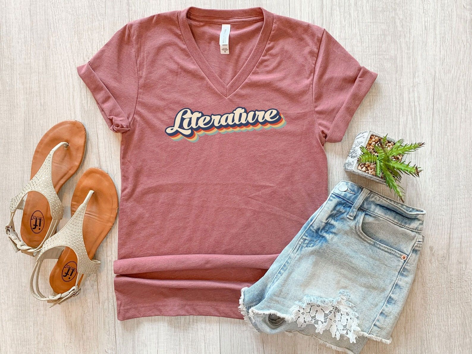 Image of a pink v-neck shirt with the word 