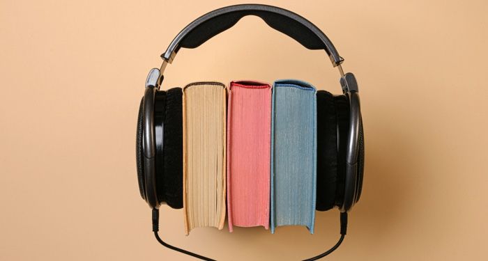 black corded headphones wrapped around a stack of colorful books