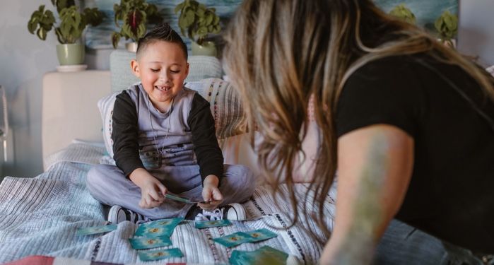 a cheerful child playing a card game with an adult