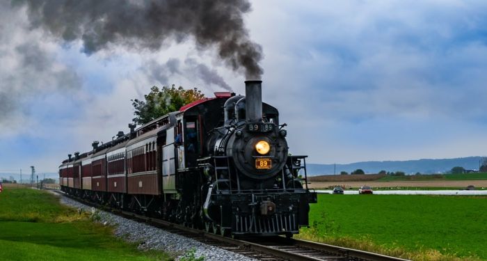 a steam engine train on train tracks