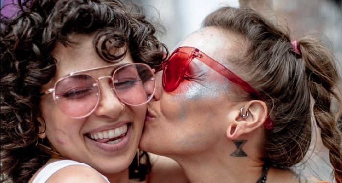 woman kissing smiling woman