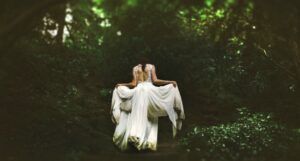 image of a woman in a white dress walking through the woods