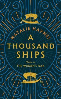 Book Cover for A Thousand Ships, featuring two golden ships sailing around a golden circle, with a Greek style pattern in blue on a dark teal background.