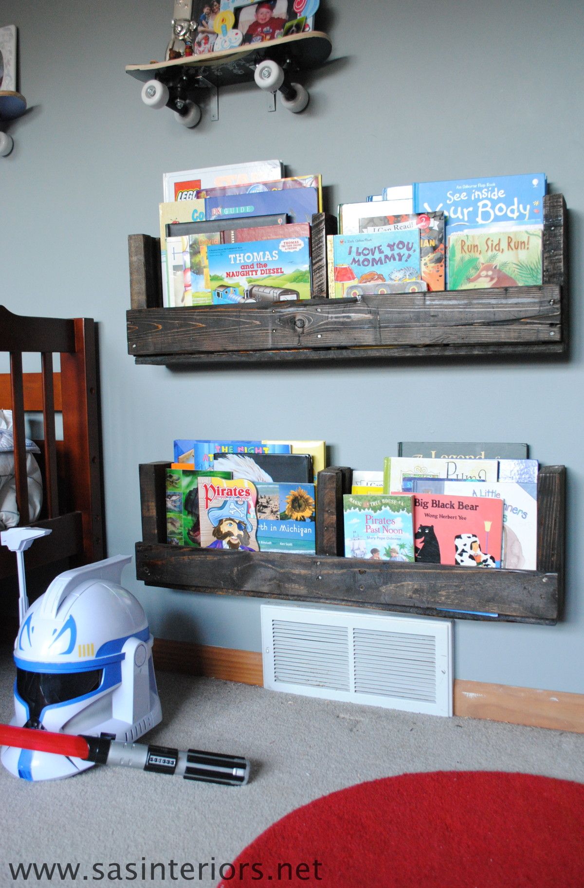 deux étagères en bois de palettes accrochées à un mur avec des livres pour enfants à l'intérieur