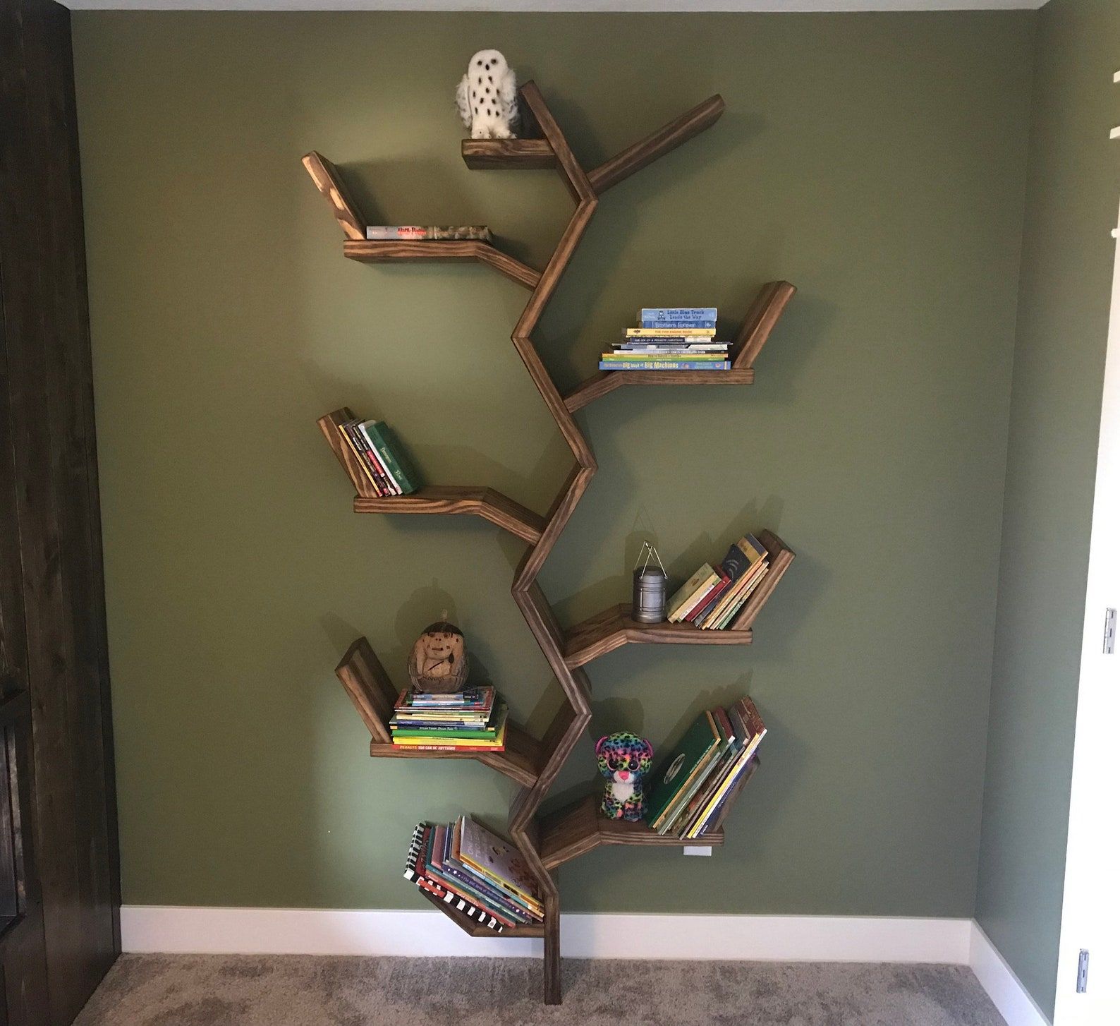 bibliothèque en forme d'arbre avec des livres sur chaque étagère de branche