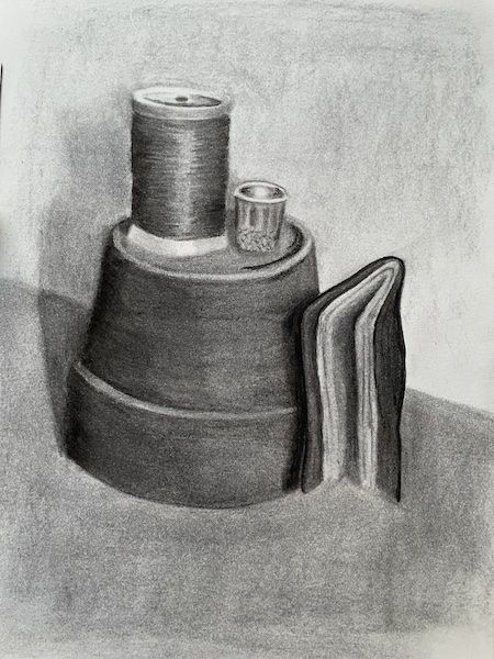 Un dessin de nature morte au fusain d'un pot de plante à l'envers avec un dé à coudre et une bobine de fil posée sur le dessus.  À côté du pot se trouve un petit cahier à couverture souple.