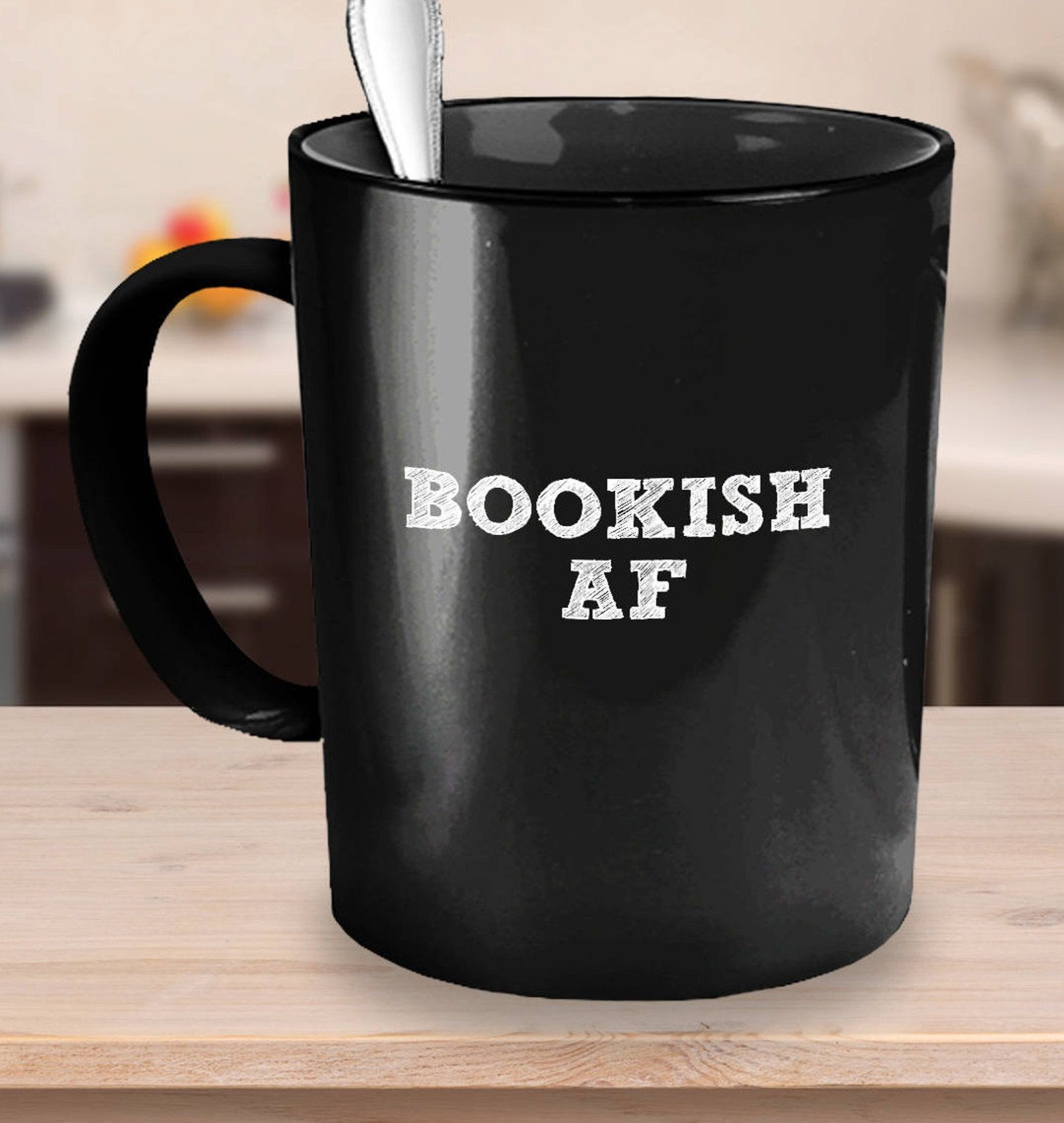 Image of a black mug on a table. In white blocky font, it reads "bookish af."