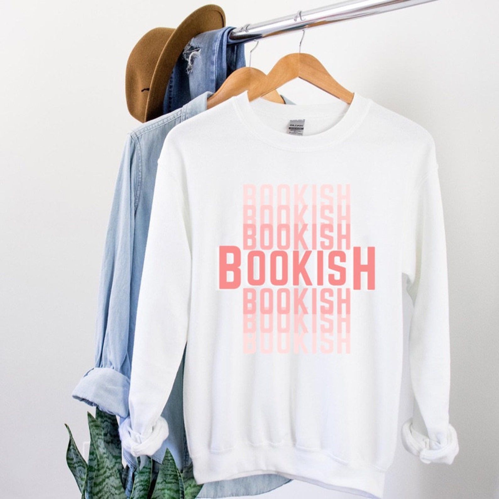 White sweatshirt with the word "Bookish" repeated in various pink shades. 