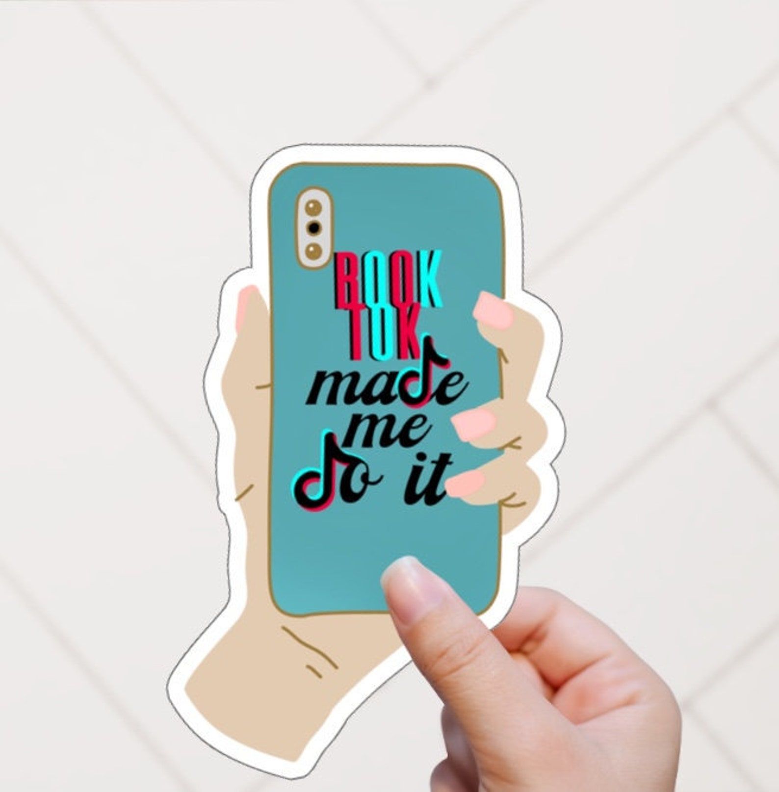 a sticker of a hand holding a phone and the words "BookTok Made Me Do It"