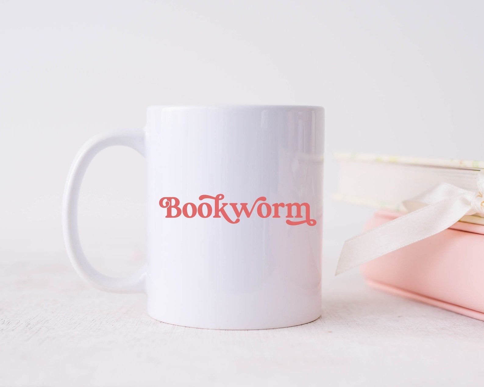 White mug with pink text. The text reads "bookworm." 